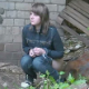An attractive girl is secretly video-recorded as she takes a piss and a shit outdoors by a brick wall - probably in Eastern Europe. There is no audio, but we can see a piss stream and a turd dropping out from between the foliage.